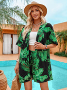 Frau in tropischem Kimono mit Blattmuster, Strohhut und weißem Top vor Pool. Sommermode, Strandkleidung, tropischer Stil, Urlaubsoutfit.