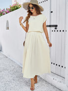 Elegantes Sommerkleid in Creme, ideal für Strandmode. Perfekt kombiniert mit Sonnenhut und Sandalen. Stilvoller Look für warme Tage.
