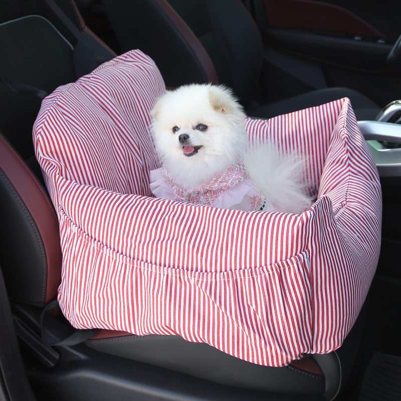 Kleiner weißer Hund in rot-weiß gestreiftem Autositz für Haustiere im Auto.