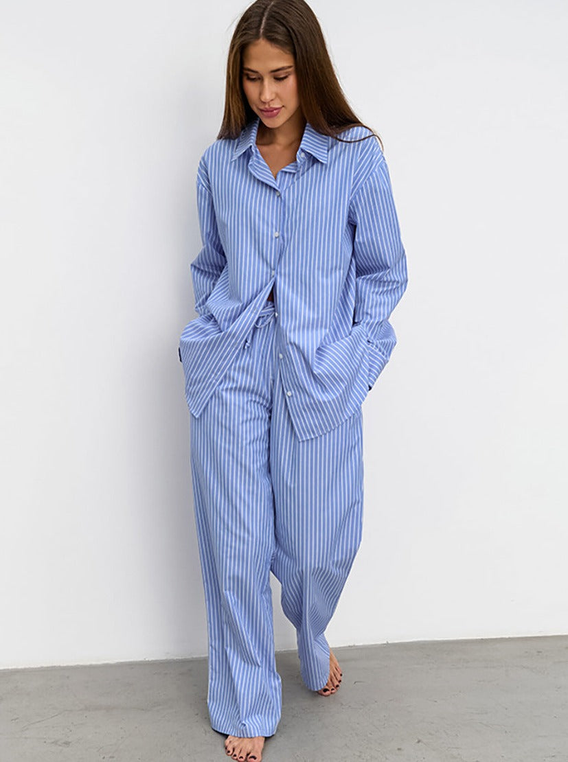 Frau in gestreiftem blauen Pyjama-Set, bequem und stilvoll, ideal für entspannte Nächte. Perfekte Nachtwäsche für Damen, modisch und gemütlich.