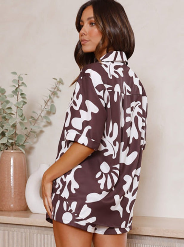 Damenhemd mit abstraktem, weißem Blumenmuster auf braunem Hintergrund. Sommermode, lässiger Stil, ideal für trendige Freizeitoutfits.