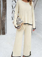 Damen-Outfit in Beige: Lässiger Zweiteiler mit Pullover und Hose, kombiniert mit einer stilvollen, gemusterten Clutch. Perfekt für den Herbst.