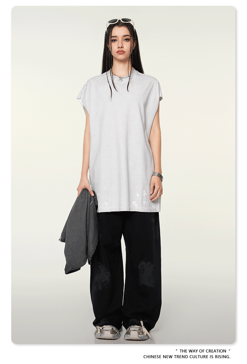 Frau in lässigem, urbanem Outfit: weißes T-Shirt, schwarze weite Hose, Sonnenbrille. Modetrend, Streetwear, asiatische Mode, minimalistisch.