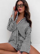 Frau in gestreiftem Hemd, sitzt lässig, trägt Sonnenbrille. Modetrend, Damenmode, Streifenlook, stilvoll, modern, Freizeitkleidung.
