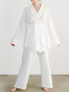 Frau in weißem Kimono-Set aus Baumwolle, ideal für Yoga oder Lounge. Bequeme, weite Passform, modisch und atmungsaktiv. Perfekt für Zuhause.