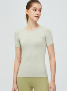 Damen-Sportshirt in Beige, kurzärmelig, atmungsaktiv, ideal für Fitness und Yoga. Hochwertige Materialien, figurbetontes Design.