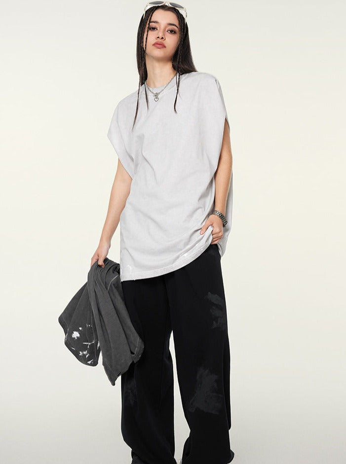 Frau in lässigem Outfit: Weißes T-Shirt, schwarze Hose, Mütze. Streetwear, Mode, urbaner Stil, trendige Kleidung, jugendlicher Look.