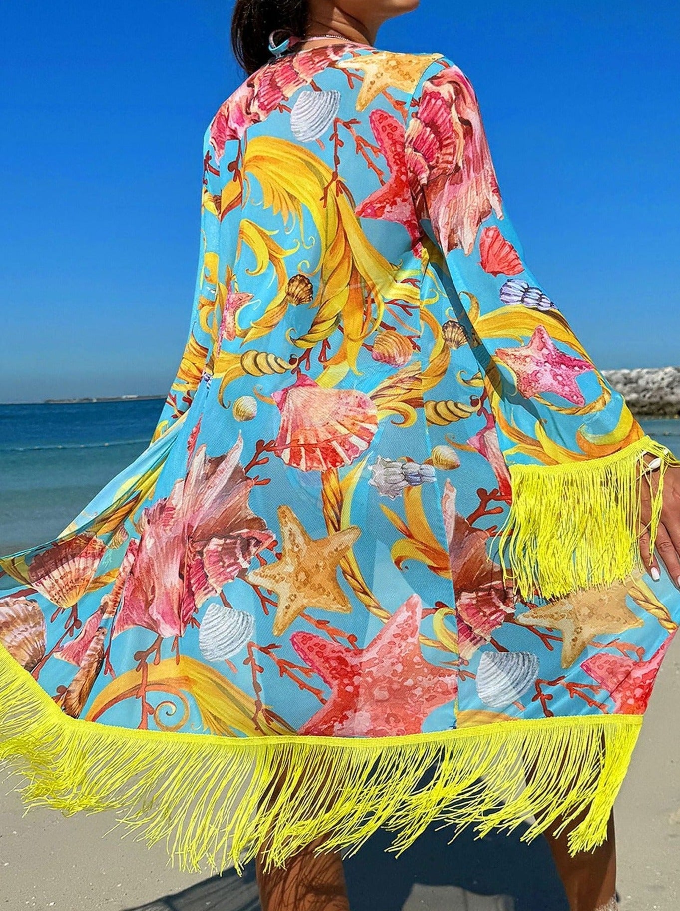 Bunter Strandkimono mit Muschel- und Seesternmuster, gelben Fransen, ideal für Sommermode, Strandbekleidung, Damenmode, Urlaub.