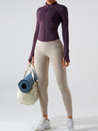 Damen-Sportbekleidung: Lila Jacke, beige Leggings, weiße Sneaker. Fitness-Outfit mit Yogamatte und Tasche. Ideal für Yoga und Workout.