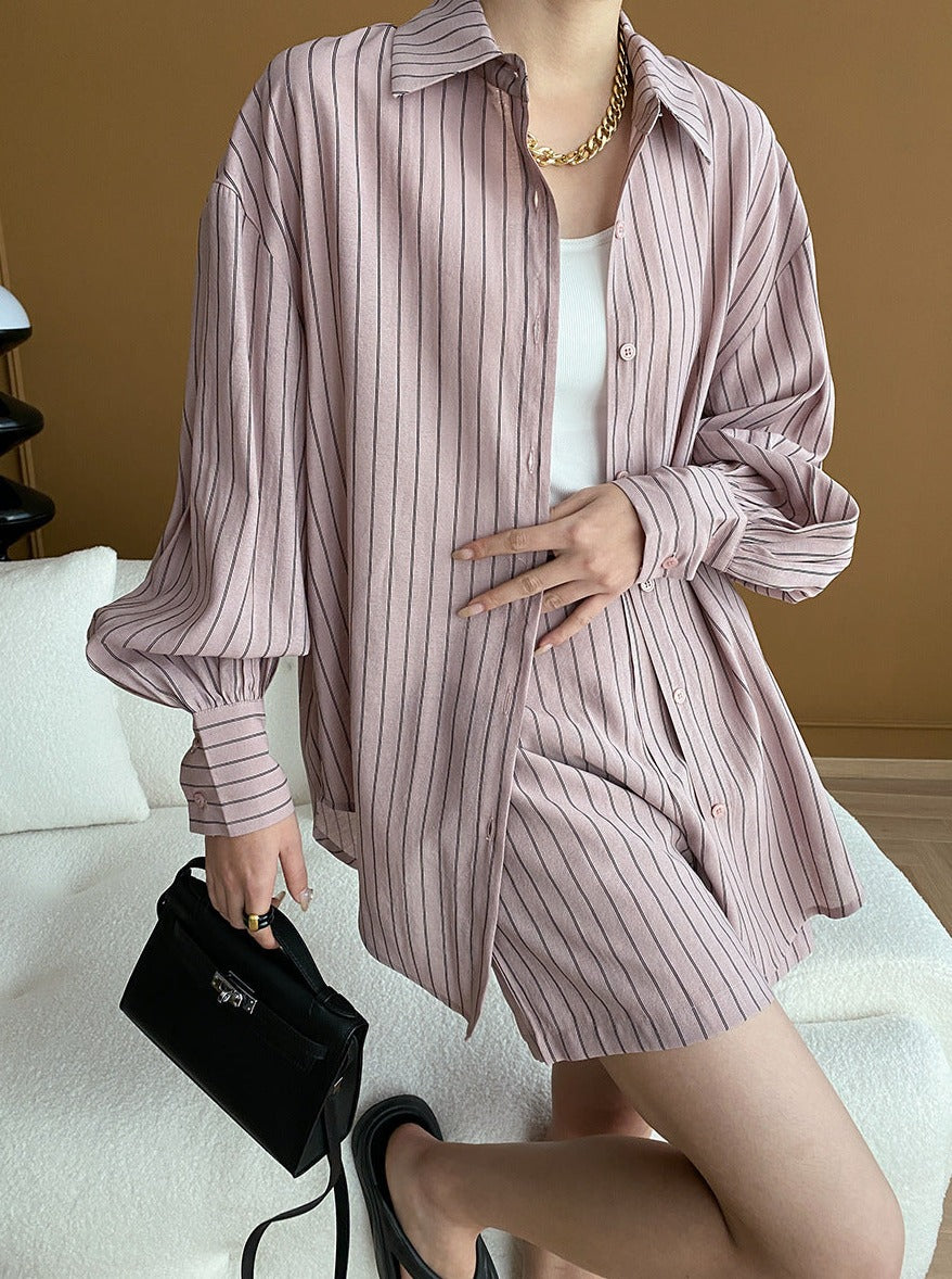 Elegantes gestreiftes Hemdkleid in Rosa, kombiniert mit schwarzer Handtasche und goldener Kette. Perfekt für modische Damen-Outfits.