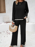 Damen-Outfit: Schwarzer Zweiteiler mit langen Ärmeln und weiten Hosen, kombiniert mit einer stilvollen Strohtasche. Perfekt für elegante Anlässe.