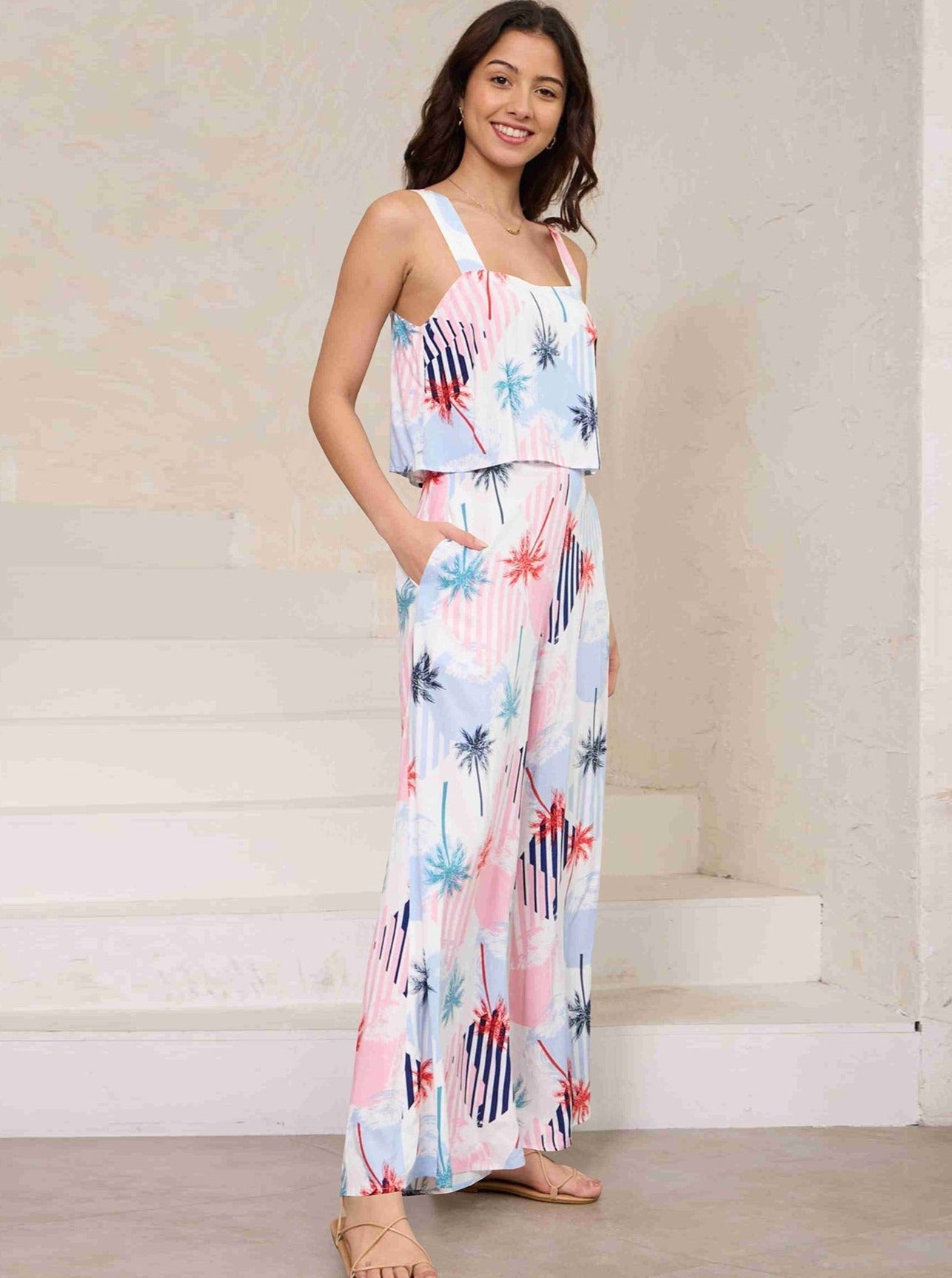 Frau in einem farbenfrohen, ärmellosen Sommerkleid mit abstraktem Muster, ideal für Strandmode. Perfekt für warme Tage und lässige Anlässe.