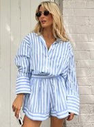 Frau in gestreiftem, blau-weißem Hemd und Shorts, trägt Sonnenbrille. Sommermode, lässiger Look, trendige Damenbekleidung, Streetstyle.