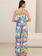 Frau in buntem, floralen Jumpsuit aus leichter Baumwolle, ideal für Sommermode. Perfekt für Strand, Urlaub und Freizeit.