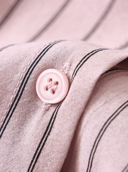 Rosa Hemdknopf auf gestreiftem Stoff, Nahaufnahme. Hochwertige Baumwolle, elegante Streifen, modisches Design, ideal für stilvolle Outfits.