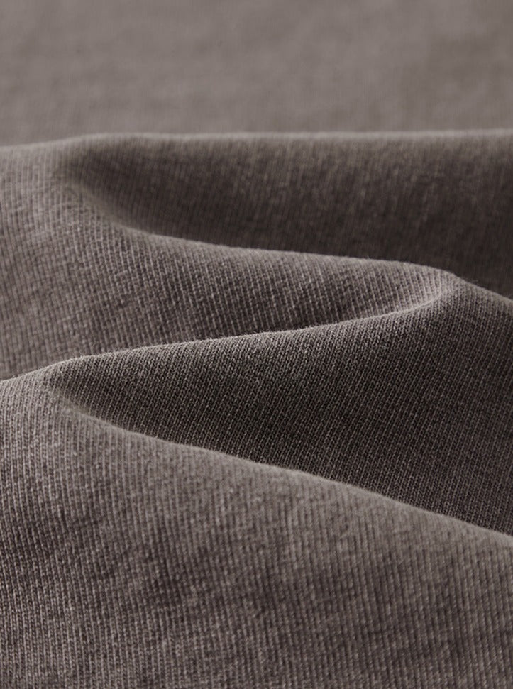 Grauer Baumwollstoff, Nahaufnahme. Weicher, hochwertiger Textilstoff, ideal für Bekleidung und Heimtextilien. Perfekt für Nähprojekte.
