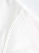 Nahaufnahme eines weißen T-Shirts aus Baumwolle, zeigt feine Nähte und weiches Material. Perfekt für minimalistische Mode und Komfort.