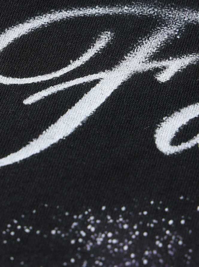 Schwarzes T-Shirt mit weißem, geschwungenem Schriftzug und dezentem Glitzereffekt. Modetrend, stilvolles Design, hochwertige Baumwolle.