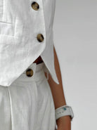 Elegante weiße Leinenweste mit Knöpfen, kombiniert mit passender Hose. Perfekt für stilvolle Sommermode und zeitlose Eleganz.