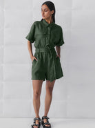 Damen Jumpsuit in Olivgrün, kurzärmelig, mit Gürtel und Knopfleiste. Perfekt für Sommermode, lässiger Stil, trendige Damenbekleidung.