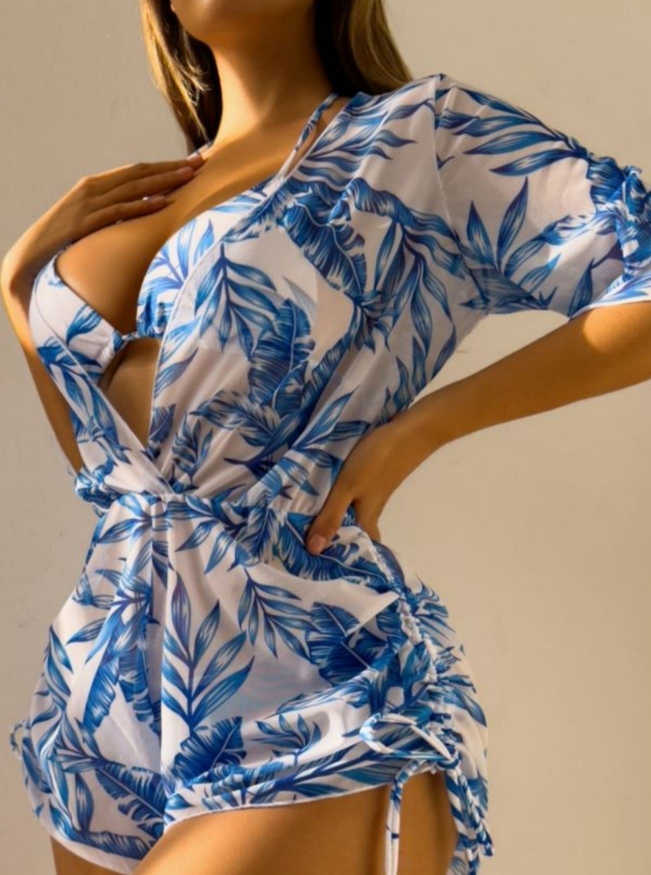 Frau in blau-weißem, tropisch bedrucktem Jumpsuit, Sommermode, stilvoller Einteiler, tropisches Design, Freizeitkleidung, Damenmode.