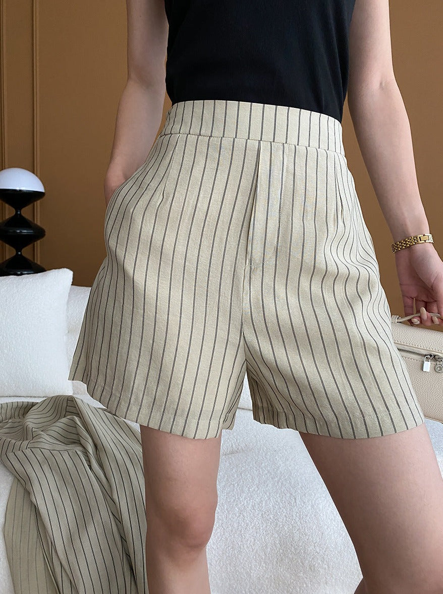 Gestreifte Damen-Shorts in Beige, elegant und modern, ideal für Sommermode. Perfekt kombinierbar mit schwarzem Top. Hochwertige Materialien.