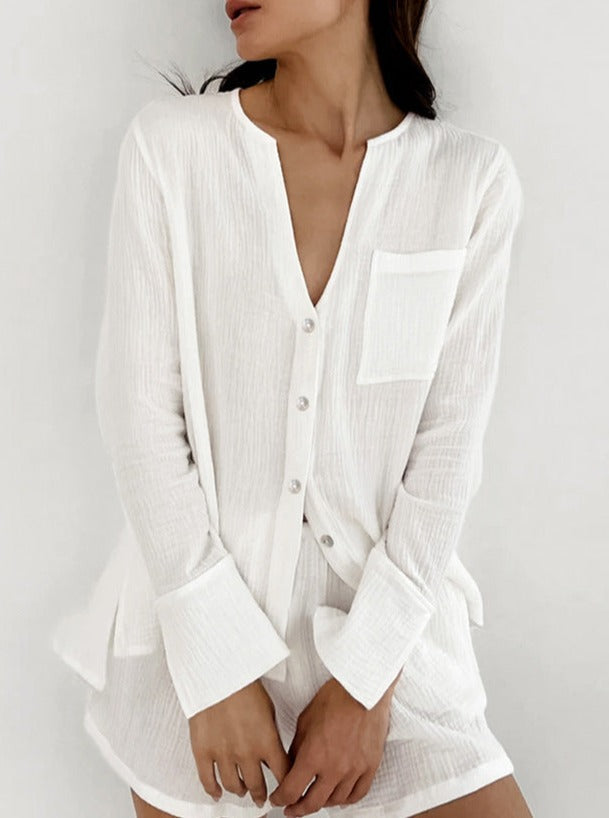 Damen Pyjama-Set aus weißem Baumwollstoff, langärmlig mit Knopfleiste und Brusttasche. Bequem, stilvoll, ideal für erholsamen Schlaf.