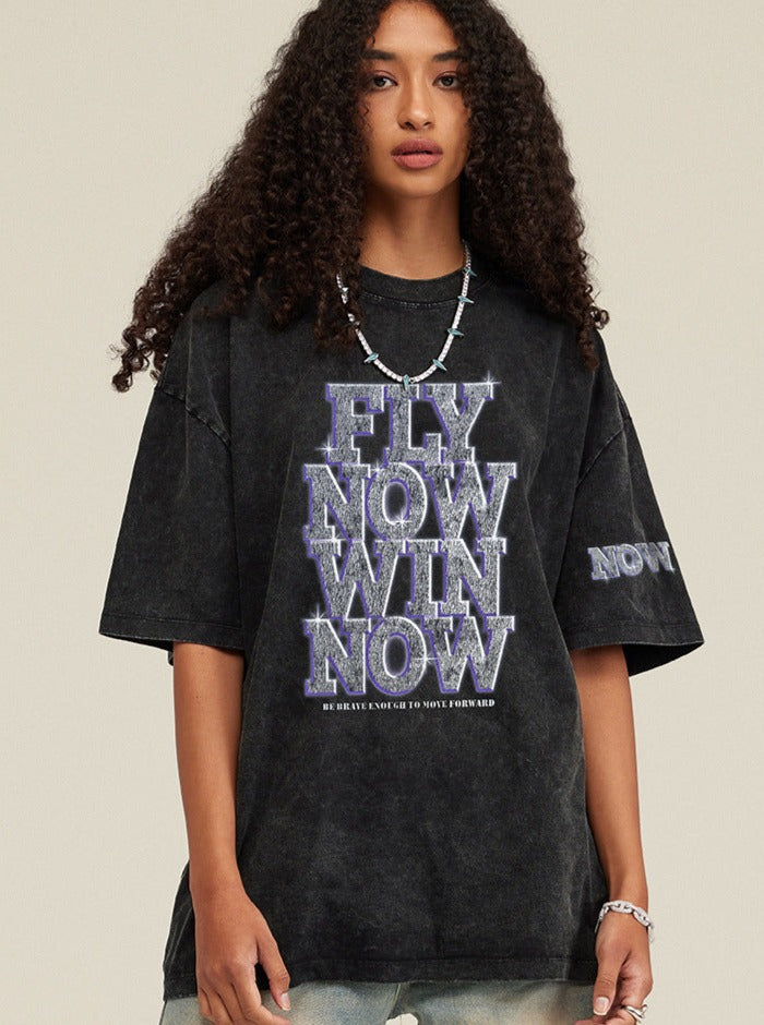 Schwarzes Oversize-T-Shirt mit "Fly Now Win Now"-Aufdruck, lässiger Streetwear-Stil, ideal für trendige Mode und urbanen Look.