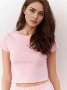 Junge Frau in rosa Crop-Top mit geometrischem Muster, lässiger Look, Mode, Damenbekleidung, trendiger Stil, Freizeitoutfit, Sommermode.