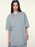 Graues Oversize-T-Shirt für Damen, lässiger Streetwear-Stil, ideal für modische Outfits. Perfekt kombinierbar mit Accessoires und urbanem Look.