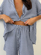 Gestreifter Pyjama-Set für Damen, bestehend aus lockerem Hemd und Shorts. Bequem, modisch, ideal für entspannte Nächte und gemütliche Tage.