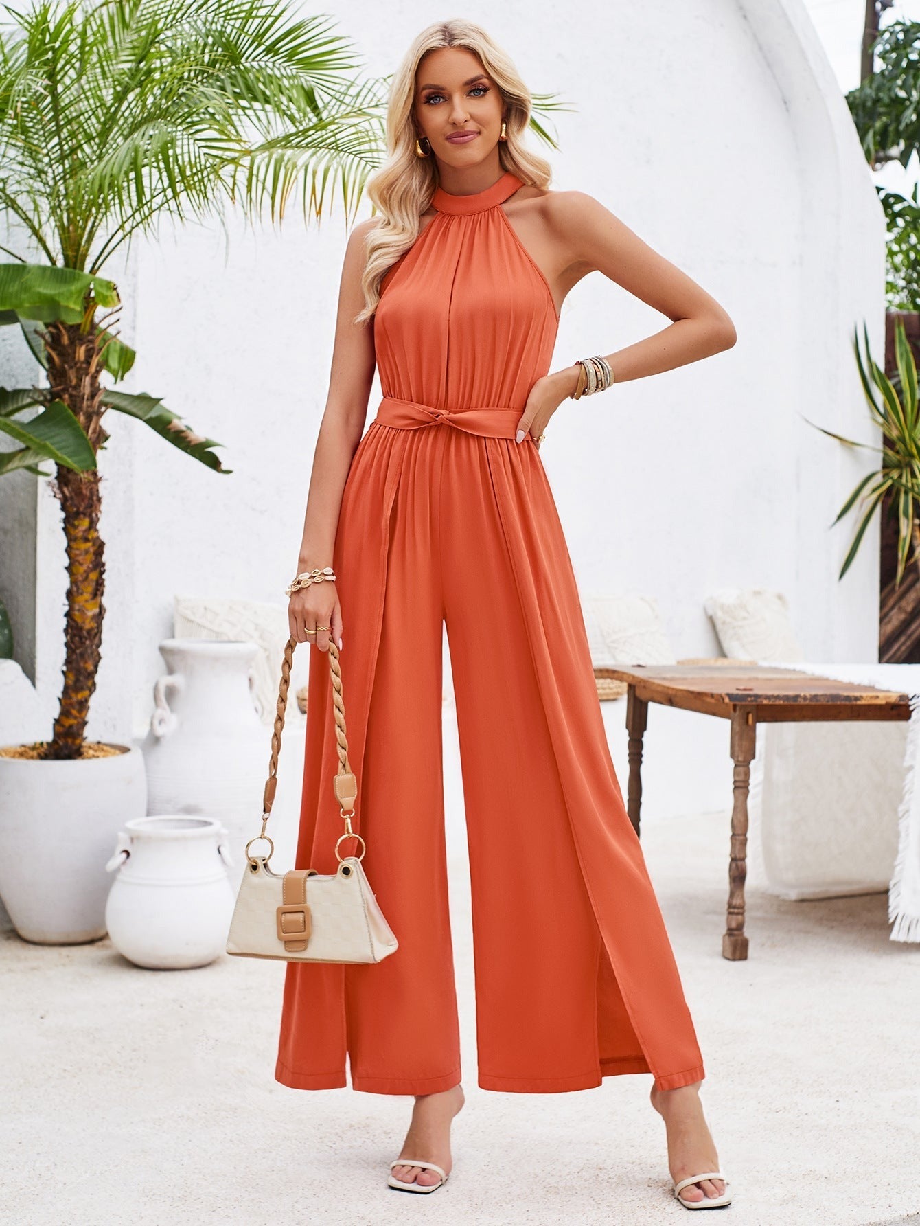 Eleganter orangefarbener Jumpsuit für Damen, ärmellos mit weitem Bein, ideal für Sommermode. Perfekt für stilvolle Anlässe und Freizeit.