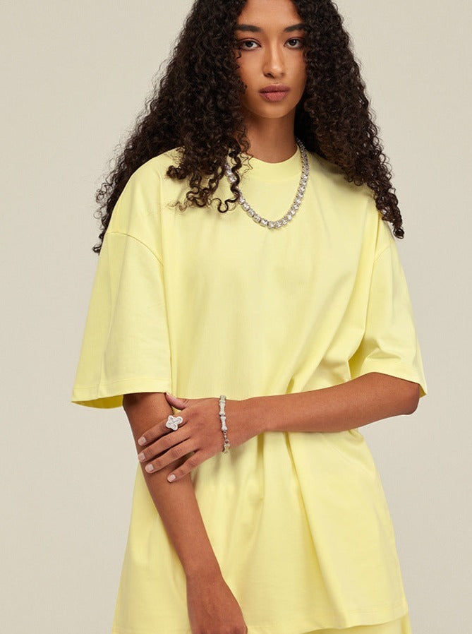 Gelbes Oversize-T-Shirt für Damen, kombiniert mit modischem Schmuck. Perfekt für lässige Outfits. Trendige Damenmode, bequem und stilvoll.