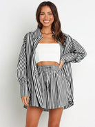 Frau in gestreiftem Zweiteiler: Schwarz-Weiß-Bluse und Rock. Modetrend, lässiger Stil, Sommeroutfit, Damenmode, Streifenmuster.