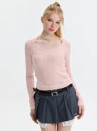 Junge Frau in rosa Strickpullover und grauem Faltenrock. Modetrend, Damenmode, stilvolle Kleidung, lässiger Look, Herbstmode.