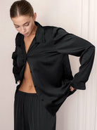 Elegante schwarze Satinbluse für Damen, ideal für stilvolle Abendmode. Hochwertiges Material, luxuriöses Design, perfekt für besondere Anlässe.