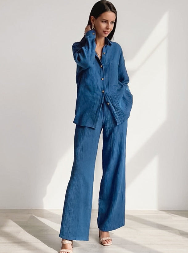 Frau in eleganter blauer Leinenhose und Hemd, modisch und stilvoll, ideal für Sommermode. Perfekt für lässige und formelle Anlässe.