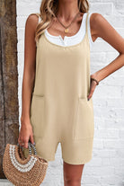 Frau in beige Jumpsuit mit weißen Top, hält eine geflochtene Strohtasche. Sommermode, lässiger Stil, trendige Damenbekleidung.
