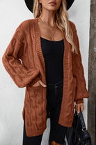 Damenmode: Langer Strickcardigan in Braun, ideal für Herbst. Kombiniert mit schwarzem Top und Jeans. Trendige, gemütliche Strickmode.