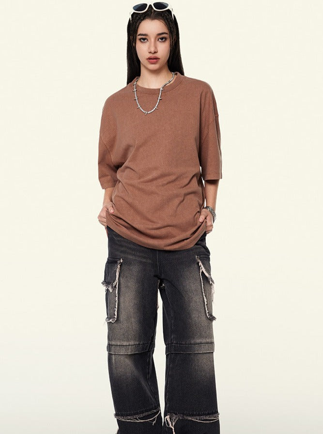 Frau in lässigem Outfit: braunes T-Shirt, schwarze Cargo-Jeans. Modetrend, Streetwear, urbaner Stil, Damenmode, Freizeitlook.