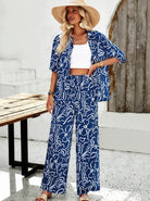 Frau in blau-weißem Sommeroutfit mit Hut, lässige Strandmode, weite Hose, gemustertes Hemd, modische Damenbekleidung, Sommertrends 2023.