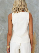 Ärmelloses weißes Top aus Baumwolle, Damenmode, Rückansicht. Sommeroutfit, lässiger Stil, ideal für warme Tage, modische Freizeitkleidung.