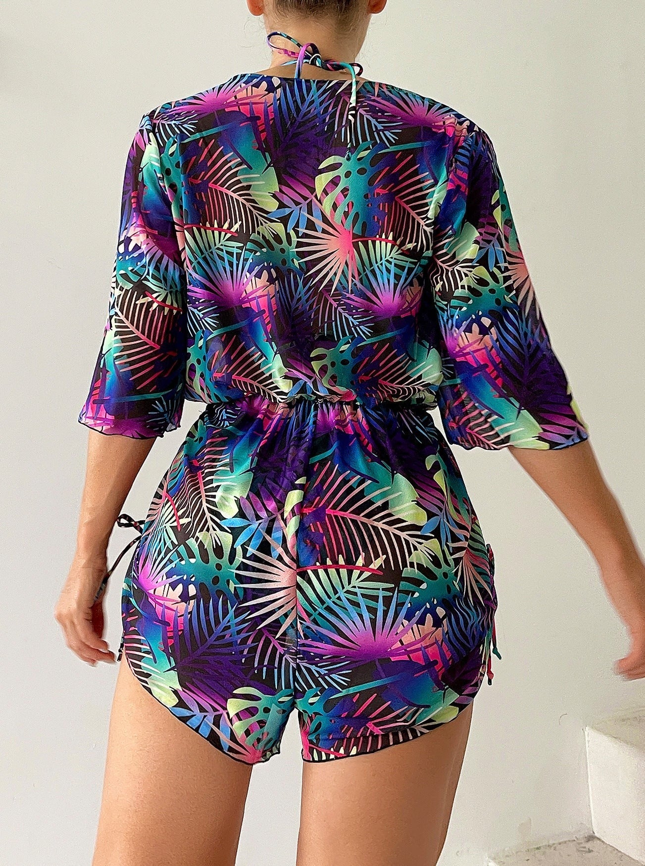 Farbintensiver Badeanzug mit tropischem Blattmuster, ideal für den Sommer. Perfekt für Strandmode und tropische Urlaubsoutfits.