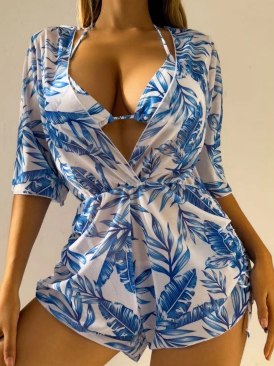 Damen Jumpsuit mit blauem Blattmuster, tiefem V-Ausschnitt und kurzen Ärmeln. Perfekt für Sommermode und Strandoutfits.