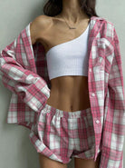 Damen-Pyjama-Set in Rosa-Karo-Design, bestehend aus Hemd und Shorts, kombiniert mit einem weißen, schulterfreien Top. Bequem und modisch.