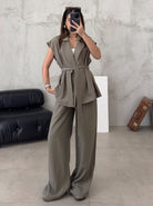 Frau in olivgrünem Hosenanzug, modisch und elegant, mit Gürtel und weitem Schnitt. Perfekt für Business-Mode und stilvolle Outfits.