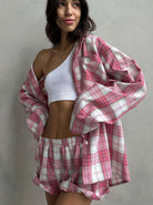 Frau in kariertem Pyjama-Set, rosa-weiß, mit einseitigem weißen Top. Bequem, modisch, Nachtwäsche, Damenmode, Freizeitlook.