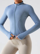 Damen-Sportjacke in Blau, eng anliegend, mit Reißverschluss und Daumenlöchern. Ideal für Fitness, Yoga und Outdoor-Aktivitäten.