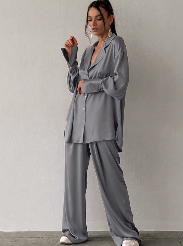 Graues Oversize-Satin-Set für Damen, bestehend aus Hemd und Hose. Modetrend, lässiger Stil, ideal für elegante Freizeitoutfits.