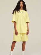 Frau in gelbem Oversize-T-Shirt und Shorts, modisch, lässig, Streetwear, Sommeroutfit, trendige Damenmode, bequeme Freizeitkleidung.